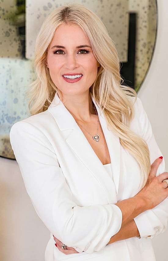 Smiling woman in a white suit portrait.